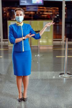 Woman stewardess in medical mask inviting to airport