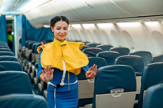 Flight attendant demonstrating how to use life vest in airplane