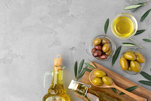 Flatlay composition of olives and olive oil on gray background