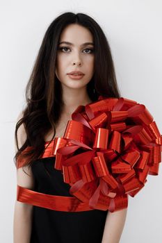 Young pretty woman wrapped with ribbon