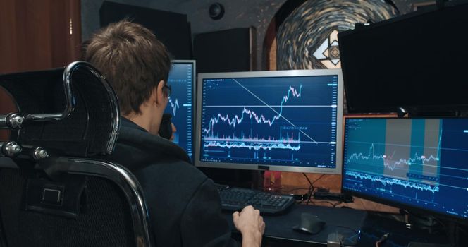 Man trader, freelancer on stock exchange trades options at home computer