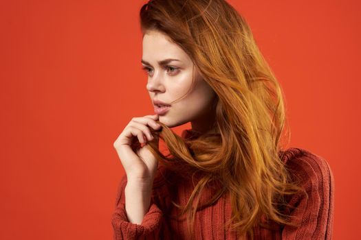 red-haired woman in red sweater fashion studio posing. High quality photo