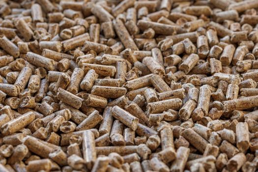 Compacted wooden sawdust pellets. Litter for pets and bio fuel, full frame closeup background with selective focus.