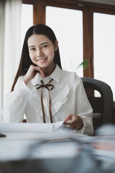 Asian Businesswoman or Accountant hands holding paperwork with calculator, account and saving concept
