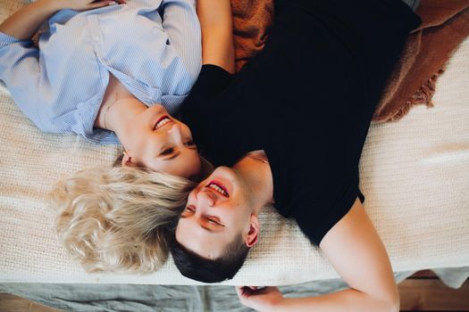 Above view of positivity couple laying together on back and happy smiling.