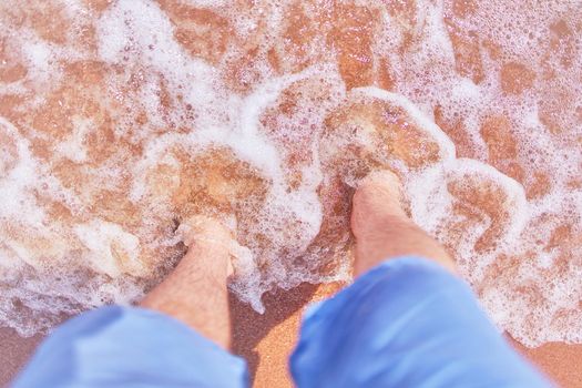 Men's feet on the beach.