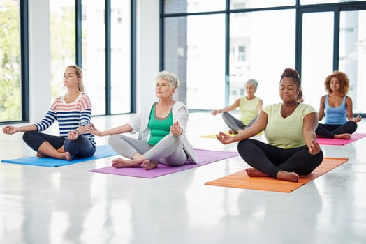 Meditation is fitness for your mind. Shot of a group of women meditating indoors.