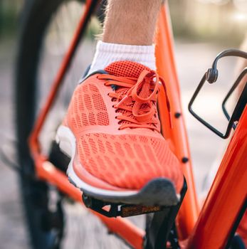 Leg in sneaker on bike pedal