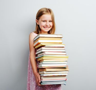 School girl holding stack of books