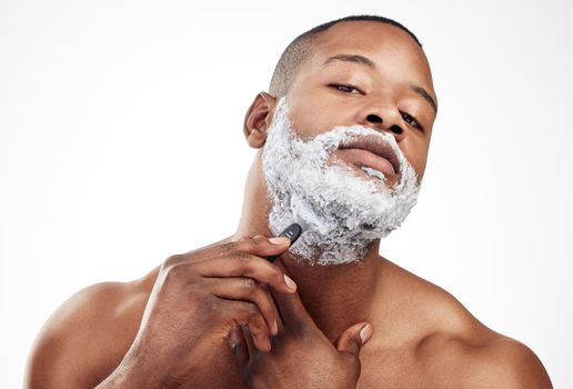 Shave regularly for a clean look. Studio portrait of a handsome young man shaving his facial hair against a white background.