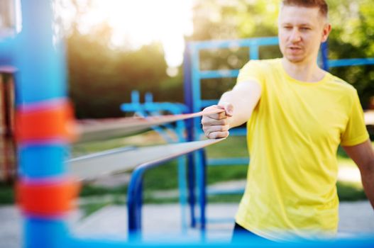 Sportive man training with resistance band