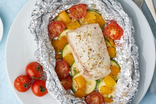 Foil pack dinner with white fish. Oven baked fillet of cod, pike perch with vegetables