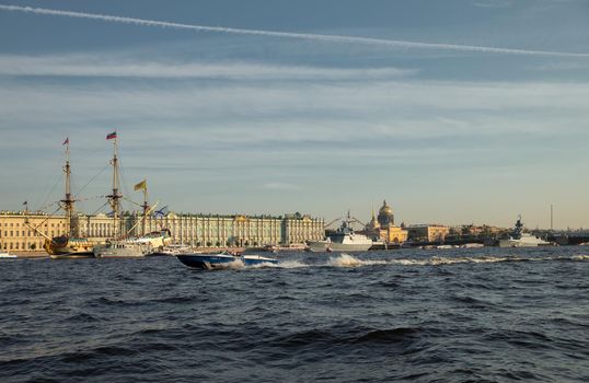 The landscape with warships in the Neva River before the holiday of the Russian Navy at sunny day, the latest cruisers among landmarks, Palace bridge
