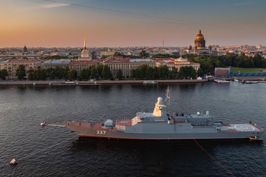 Aerial morning urban landscape with warships in the waters of the Neva River before the holiday of the Russian Navy, sea power, the latest cruisers among the sights, Isaac cathedral on a background