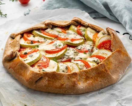 Homemade savory galette with vegetables, wholegrain pie with tomatoes, zucchini