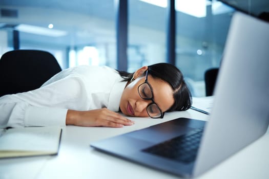 Ive been so tired lately. Shot of a young businesswoman taking a nap at her desk.