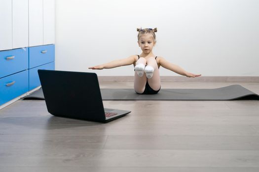 online training of a Caucasian girl gymnast 5 years old
