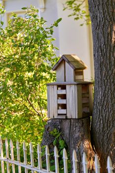 Multi storey bird house on a tree stump in the park