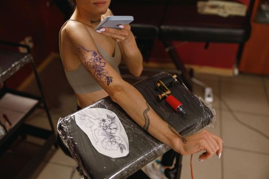 Woman customer making photo of tattoo in salon