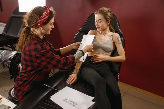 Tattoo artist placing paper with pattern on hand