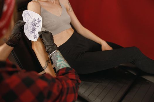 Tattoo artist applying transfer paper with pattern to the body