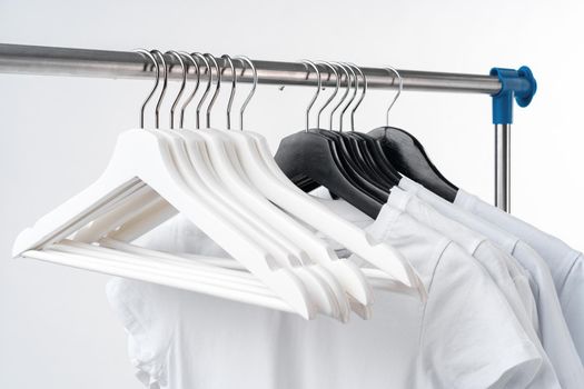 Clothes hang on clothing rack over white background.