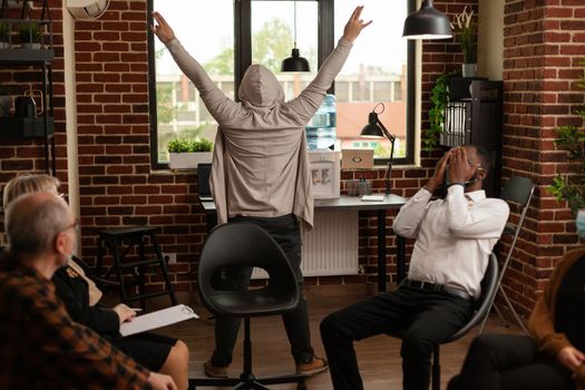 Man fooling around in front of people at group therapy session
