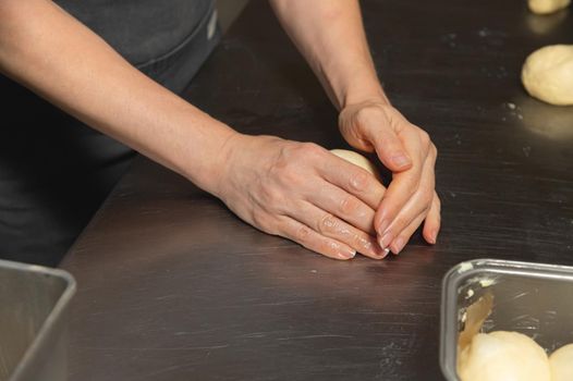 Baker making bread, female hands, kneading dough, cooking