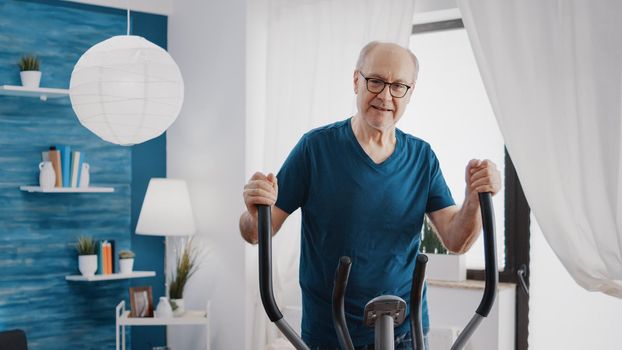 Elder adult doing physical cardio exercise on fitness bicycle