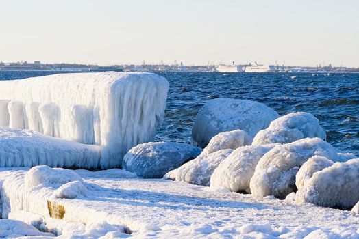 Winter on shore of the Baltic Sea. Lighthouse in ice. Baltic Sea and frozen pier in winter, Tallinn Estonia, weather cast concept