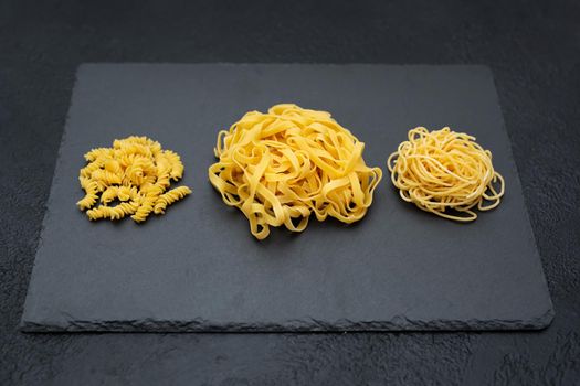 Raw pasta, isolated on a black background, top view