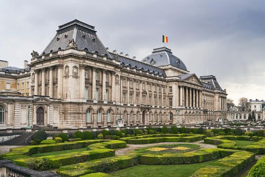 The Royal Palace in Brussels, Belgium from the northeastern corner in spring. National flag of the Kingdom of Belgium waving on top.