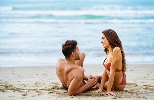 Caucasian couple on sandy beach near sea