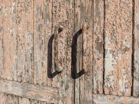 Vintage door handle antiquity on painted wood frame. Old paint layers. Grunge. Old door knobs on a wooden door.