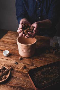 Man Putting Clay Pebbles on the Bottom of Pot