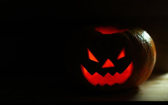 Halloween pumpkin with scary face on black background