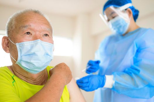 Doctor doing vaccine injection to senior man
