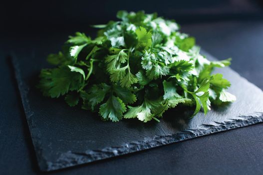 fresh dill and parsley on a black board