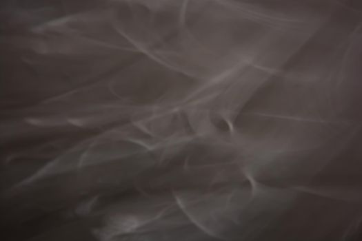 Dark gray background with white blurry waves. Smoke abstraction.