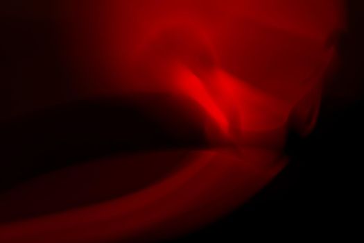 Red abstract glare on a black background.