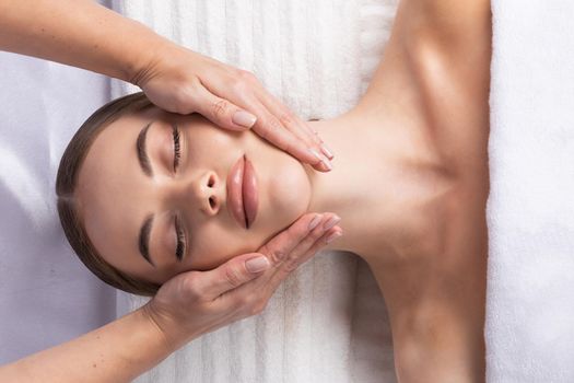 Massage therapist massaging woman face