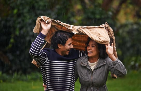 Here comes the rain. Cropped shot of an affectionate young couple trying to escape the rain.