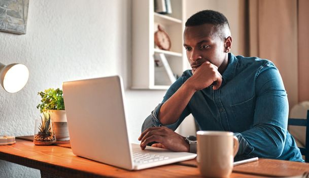 Is this really the best business move. Cropped shot of a handsome young businessman sitting in his home office and looking contemplative while working on his laptop.