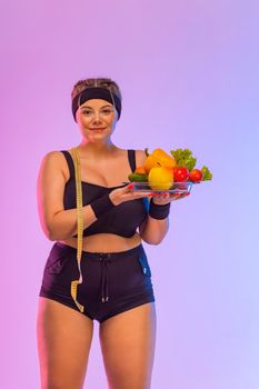 Fat girl size plus model with vegetables and measuring tape.