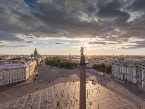 Aerial view of Palace Square and Alexandr Column at sunset, a gold dome of St. Isaac's Cathedral, golden spire of Admiralty building, the Winter Palace, long shadows, cloud