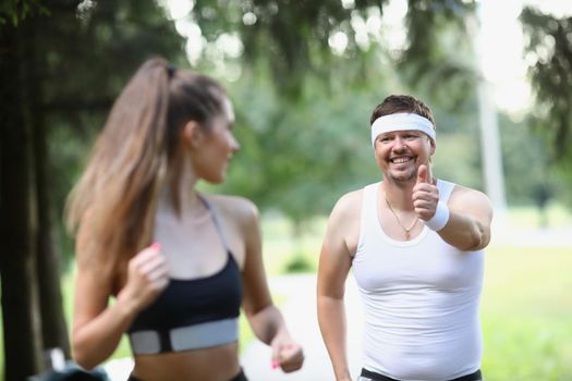 Tired middle aged man running in early morning with woman friend