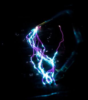 blue and purple taser electric discharge on black