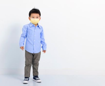 child standing over white background and wearing face mask