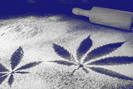 The process of making cannabis pastries. You can see a , a rolling pin, traces of marijuana leaves on flour. Monochrome. tinting Phantom Blue
