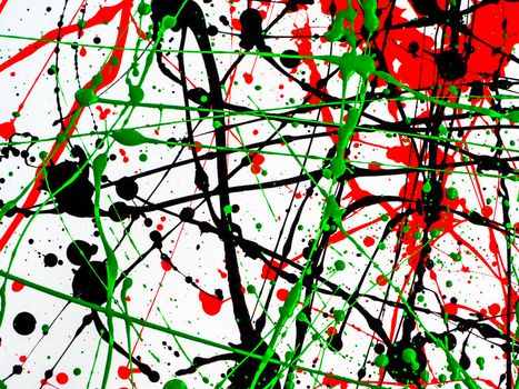 red black green paint splattered with lines and drops on a white surface